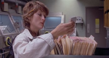 Movie still from “Silkwood” (1983), directed by Mike Nichols – A woman looking at a phone in front of a pile of papers; Close Up shot, Low angle