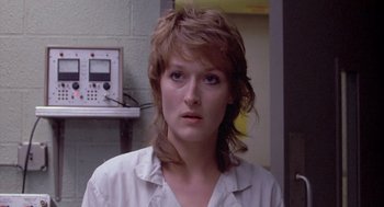 Movie still from “Silkwood” (1983), directed by Mike Nichols – A woman in a white shirt is looking at the camera; Close Up shot, Over the shoulder angle