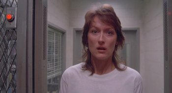Movie still from “Silkwood” (1983), directed by Mike Nichols – A woman in a white shirt is in a room; Close Up shot, Over the shoulder angle