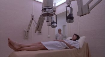 Movie still from “Silkwood” (1983), directed by Mike Nichols – A woman laying on a bed in a room; Wide shot, Low angle
