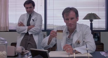 Movie still from “Silkwood” (1983), directed by Mike Nichols – Two men in white lab coats are drinking coffee; Medium shot, Low angle