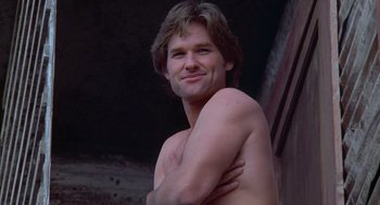 Movie still from “Silkwood” (1983), directed by Mike Nichols – A shirtless man with his arms around his chest; Close Up shot, Low angle