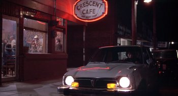 Movie still from “Silkwood” (1983), directed by Mike Nichols – A car parked in front of a restaurant at night; Wide shot, Low angle