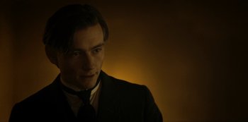 Movie still from “A Fortunate Man” (2018), directed by Bille August – A man in a suit and tie looking at the camera; Close Up shot, Over the shoulder angle