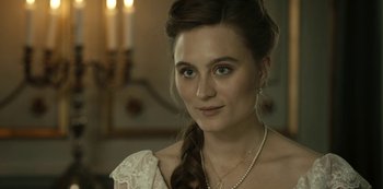 Movie still from “A Fortunate Man” (2018), directed by Bille August – A beautiful young lady wearing a white dress and pearls; Close Up shot, Over the shoulder angle