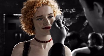 Movie still from “Sin City: A Dame to Kill For” (2014), directed by Frank Miller – A woman holding a coin in front of a man; Extreme Close Up shot, Over the shoulder angle