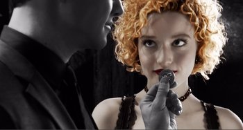 Movie still from “Sin City: A Dame to Kill For” (2014), directed by Frank Miller – A man and a woman are holding a microphone; Extreme Close Up shot, Over the shoulder angle