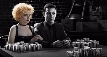 Movie still from “Sin City: A Dame to Kill For” (2014), directed by Frank Miller – A man and a woman sitting in front of stacks of coins; Medium shot, Low angle
