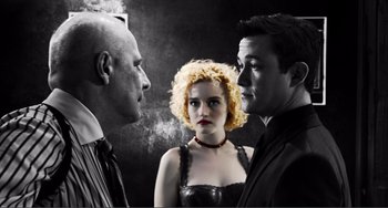 Movie still from “Sin City: A Dame to Kill For” (2014), directed by Frank Miller – Two men and a woman standing next to each other; Medium shot, Low angle