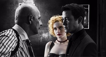Movie still from “Sin City: A Dame to Kill For” (2014), directed by Frank Miller – A man and a woman standing next to each other; Medium shot, Low angle