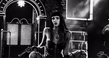 Movie still from “Sin City: A Dame to Kill For” (2014), directed by Frank Miller – A black and white photo of a woman in a leather outfit; Medium shot, Low angle