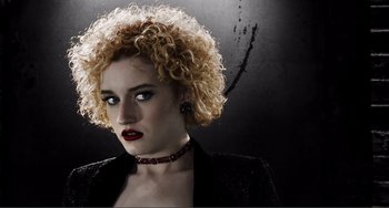 Movie still from “Sin City: A Dame to Kill For” (2014), directed by Frank Miller – A person with curly blonde hair; Close Up shot, Low angle