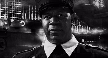 Movie still from “Sin City: A Dame to Kill For” (2014), directed by Frank Miller – A black and white photo of a man in a uniform; Close Up shot, Low angle