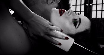 Movie still from “Sin City: A Dame to Kill For” (2014), directed by Frank Miller – A woman with red lipstick on her face and a man with green eyes; Extreme Close Up shot, Overhead angle