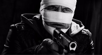 Movie still from “Sin City: A Dame to Kill For” (2014), directed by Frank Miller – A man with bandages on his head holding a gun; Extreme Close Up shot, Low angle