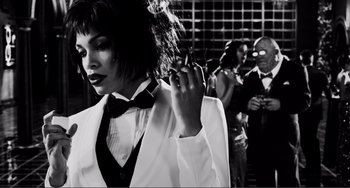 Movie still from “Sin City: A Dame to Kill For” (2014), directed by Frank Miller – A black and white photo of a woman smoking a cigarette; Medium shot, Low angle