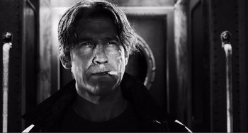 Movie still from “Sin City: A Dame to Kill For” (2014), directed by Frank Miller – Black and white photograph of a man smoking a cigarette; Close Up shot, Low angle