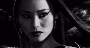 Movie still from “Sin City: A Dame to Kill For” (2014), directed by Frank Miller – A person wearing a black dress; Close Up shot, Low angle