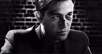 Movie still from “Sin City: A Dame to Kill For” (2014), directed by Frank Miller – Black and white photograph of a man in a suit and tie; Close Up shot, High angle