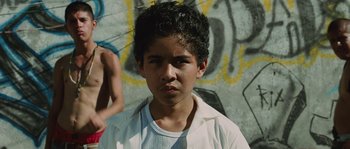 Movie still from “Sin Nombre” (2009), directed by Cary Joji Fukunaga – A young boy is standing in front of a graffiti wall; Close Up shot, Low angle