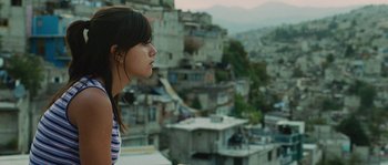 A woman looking out over a city from a balcony