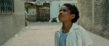 Movie still from “Sin Nombre” (2009), directed by Cary Joji Fukunaga – A young man standing on the side of the street; Close Up shot, Low angle