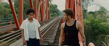 Movie still from “Sin Nombre” (2009), directed by Cary Joji Fukunaga – Two young men standing next to each other on train tracks; Medium shot, Over the shoulder angle