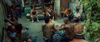 Movie still from “Sin Nombre” (2009), directed by Cary Joji Fukunaga – A group of people sitting around a living room; Wide shot, High angle