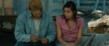 Movie still from “Sin Nombre” (2009), directed by Cary Joji Fukunaga – A man and a woman sitting next to each other on a bench; Medium shot, High angle