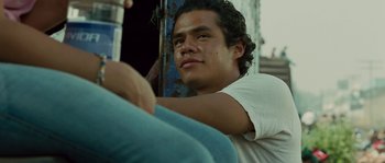 Movie still from “Sin Nombre” (2009), directed by Cary Joji Fukunaga – A man sitting on top of a metal pole; Close Up shot, Low angle