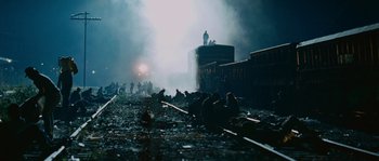 Movie still from “Sin Nombre” (2009), directed by Cary Joji Fukunaga – A group of people standing on top of a train track; Extreme Wide shot, High angle