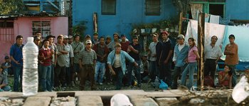 Movie still from “Sin Nombre” (2009), directed by Cary Joji Fukunaga – A group of men standing next to each other in front of a building; Wide shot, Low angle