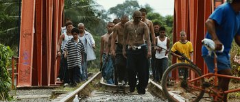Movie still from “Sin Nombre” (2009), directed by Cary Joji Fukunaga – A group of people walking on a train track; Wide shot, Low angle