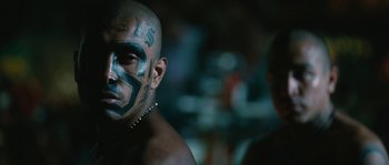Movie still from “Sin Nombre” (2009), directed by Cary Joji Fukunaga – A man that has a tattoo on his face; Close Up shot, Over the shoulder angle