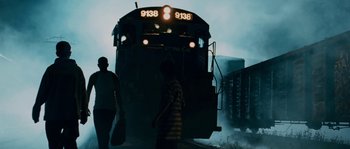 Movie still from “Sin Nombre” (2009), directed by Cary Joji Fukunaga – Two people walking on a train track near a train; Wide shot, Low angle