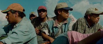 Movie still from “Sin Nombre” (2009), directed by Cary Joji Fukunaga – A group of men sitting next to each other on the ground; Medium shot, Low angle