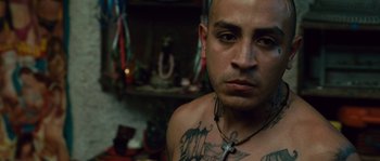Movie still from “Sin Nombre” (2009), directed by Cary Joji Fukunaga – A person with a tattoo on their chest; Close Up shot, Low angle