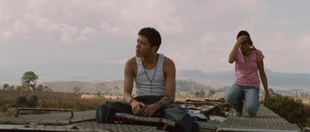 Movie still from “Sin Nombre” (2009), directed by Cary Joji Fukunaga – A man sitting on top of a metal platform; Medium shot, Low angle