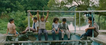 Movie still from “Sin Nombre” (2009), directed by Cary Joji Fukunaga – A group of children sitting on a ledge; Wide shot, Low angle