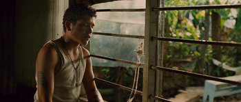 Movie still from “Sin Nombre” (2009), directed by Cary Joji Fukunaga – A man sitting on a bench looking out of a window; Close Up shot, High angle