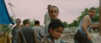 Movie still from “Sin Nombre” (2009), directed by Cary Joji Fukunaga – A group of men standing next to each other on a field; Close Up shot, Low angle