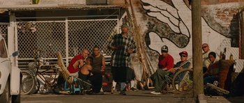 Movie still from “Sin Nombre” (2009), directed by Cary Joji Fukunaga – A group of men sitting on the side of the street; Wide shot, Low angle