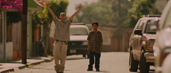 Movie still from “Sin Nombre” (2009), directed by Cary Joji Fukunaga – Two young men are walking down the street; Medium shot, Low angle
