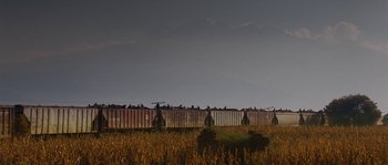 Movie still from “Sin Nombre” (2009), directed by Cary Joji Fukunaga – A train traveling down tracks next to a field of tall grass; Extreme Wide shot, Low angle
