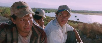 Movie still from “Sin Nombre” (2009), directed by Cary Joji Fukunaga – A group of men standing next to each other; Medium shot, Low angle