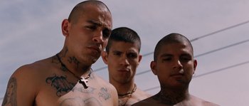 Movie still from “Sin Nombre” (2009), directed by Cary Joji Fukunaga – A group of tattooed men standing next to each other; Close Up shot, Low angle