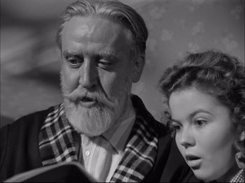 Movie still from “Since You Went Away” (1944), directed by John Cromwell – An older man and a young girl looking at a book; Close Up shot, Low angle