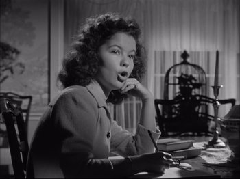 Movie still from “Since You Went Away” (1944), directed by John Cromwell – A woman sitting at a table with a bird cage in the background; Close Up shot, Low angle