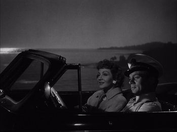 Movie still from “Since You Went Away” (1944), directed by John Cromwell – A man and a woman sitting in the back seat of a car; Medium shot, Low angle