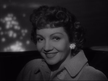 Movie still from “Since You Went Away” (1944), directed by John Cromwell – An old black and white photo of a woman smiling for the camera; Close Up shot, Low angle